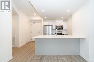 Ottawa condo for rent - A kitchen with white cabinets and a stainless steel refrigerator.