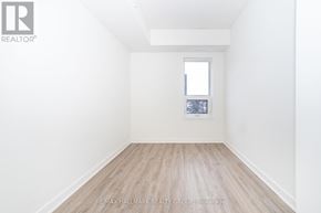Ottawa condo for rent - A white room with a window and a wooden floor.