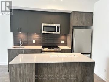 Toronto (Birchcliffe-Cliffside) townhouse for rent - A kitchen with a counter top and a microwave above it.