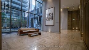 Toronto (Church-Yonge Corridor) condo for rent - A modern office lobby with a wooden bench and a framed picture on the wall.