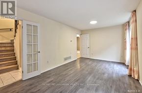 Toronto (Steeles) apartment for rent - A spacious room with wooden flooring and a staircase on the left side.