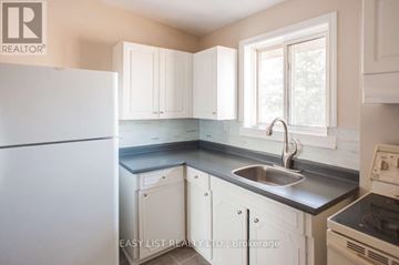 Windsor condo for rent - A kitchen with white cabinets and a stainless steel sink.