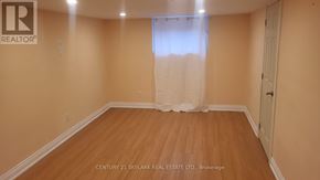 Toronto (Clairlea-Birchmount) apartment for rent - A room with wooden flooring and a window with white curtains.