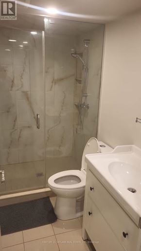 Toronto (Clairlea-Birchmount) apartment for rent - A white toilet sits next to a sink in a bathroom.