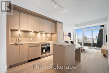 Toronto (Bayview Village) condo for rent - A modern kitchen with wooden cabinets and a large window.
