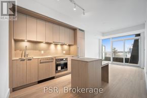 Toronto (Bayview Village) condo for rent - A modern kitchen with wooden cabinets and a large window.