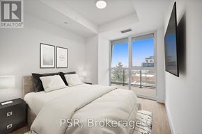 Toronto (Bayview Village) condo for rent - A bedroom with a large bed and a flat screen TV mounted on the wall.