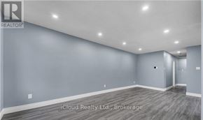 London East (East D) apartment for rent - A spacious room with grey walls and wooden flooring.