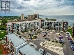 Hamilton (Stoney Creek) condo for rent - A large apartment complex with a parking lot in front.