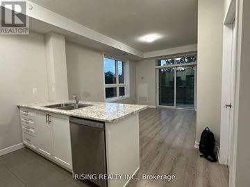 Hamilton (Stoney Creek) condo for rent - A kitchen with white cabinets and a marble countertop.