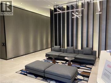 Hamilton condo for rent - A modern living room with a grey sofa and a glass partition.