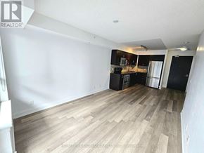 Richmond Hill (Doncrest) condo for rent - A room with wooden flooring and a kitchen area in the background.