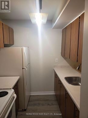Sault Ste Marie multi-family for rent - A kitchen with a refrigerator, sink, and stove.