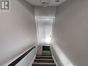 Clarington (Bowmanville) apartment for rent - A hallway with a door at the end and a brokerage logo on the wall.