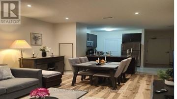 Markham (Cedarwood) condo for rent - A well-lit living room with a grey sofa, a wooden coffee table, and a dining table set for two.