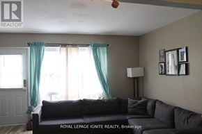 Brantford townhouse for rent - A living room with a couch and a fan.