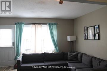 Brantford townhouse for rent - A living room with a couch and a fan.