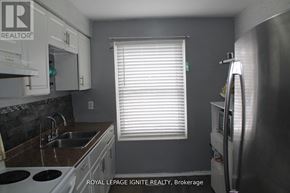 Brantford townhouse for rent - A kitchen with a stove top oven, sink, and refrigerator.