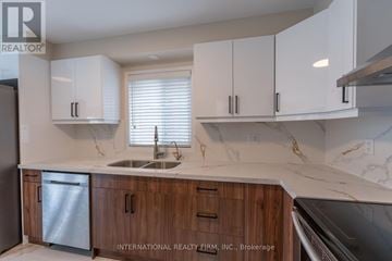 Brantford apartment for rent - A kitchen with white cabinets and a marble countertop.