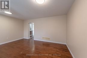 Brantford apartment for rent - A room with wooden floors and a white ceiling with a light fixture.