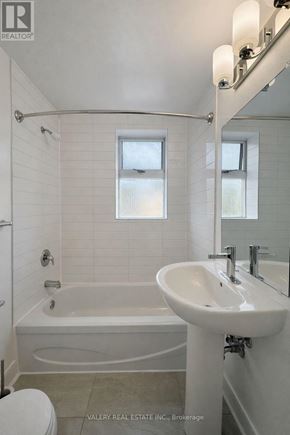 Toronto (Cabbagetown-South St. James Town) condo for rent - A white bathroom with a tub, sink, and toilet.