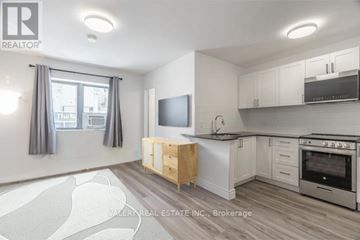 Toronto (Church-Yonge Corridor) condo for rent - A kitchen with a wooden table and a flat screen TV mounted on the wall.