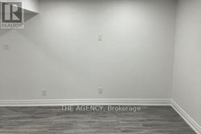Ajax (Northeast Ajax) apartment for rent - A room with a grey floor and a white wall with a logo and text on it.