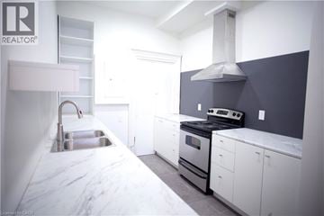 Hamilton townhouse for rent - A modern kitchen with white cabinets and a marble countertop.