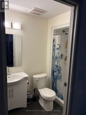 Waterloo condo for rent - A bathroom with a toilet, sink, and shower.