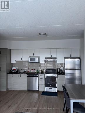 Waterloo condo for rent - A modern kitchen with stainless steel appliances and white cabinets.