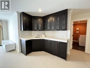 Vancouver apartment for rent - A modern kitchen with black cabinets and a white countertop.