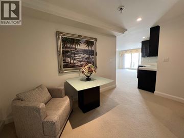 Vancouver apartment for rent - A living room with a couch, a coffee table, and a painting of a beach scene on the wall.
