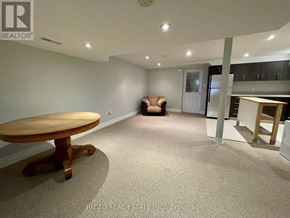 Toronto (Woodbine-Lumsden) apartment for rent - A room with a round wooden table and a brown sofa.
