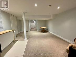 Toronto (Woodbine-Lumsden) apartment for rent - A spacious room with a carpeted floor and a wooden table in the middle.