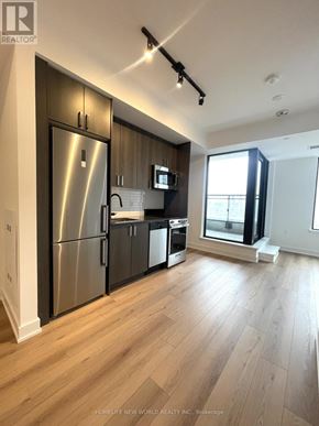 Toronto (Dovercourt-Wallace Emerson-Junction) condo for rent - A modern kitchen with wooden floors and stainless steel appliances.
