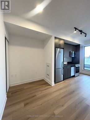 Toronto (Dovercourt-Wallace Emerson-Junction) condo for rent - A well lit kitchen with a refrigerator and a microwave.