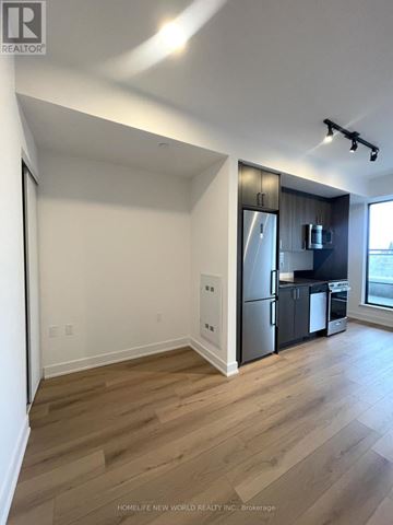 Toronto (Dovercourt-Wallace Emerson-Junction) condo for rent - A well lit kitchen with a refrigerator and a microwave.