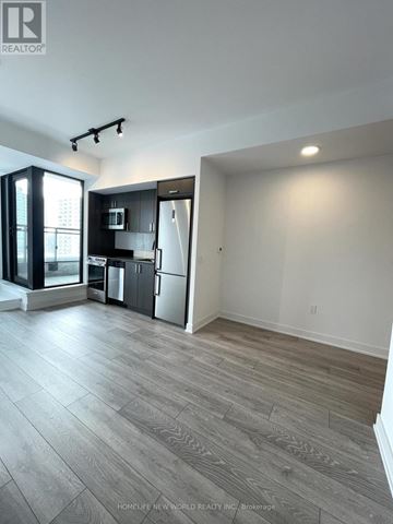 Toronto (Dovercourt-Wallace Emerson-Junction) condo for rent - A spacious kitchen with a refrigerator, microwave, and oven.