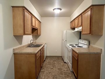 Vicksburg apartment for rent - A kitchen with brown cabinets and a white refrigerator.