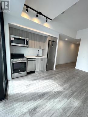Toronto (Dovercourt-Wallace Emerson-Junction) condo for rent - A modern kitchen with stainless steel appliances and a wooden floor.