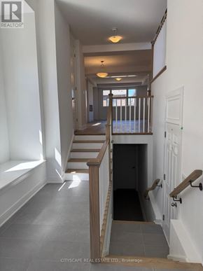 Barrie apartment for rent - A hallway with a staircase and a door at the end.