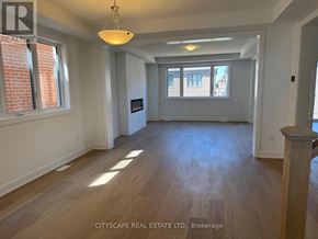 Barrie apartment for rent - A spacious room with wooden floors and a large window.