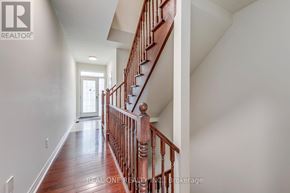 Oakville (Wm Westmount) townhouse for rent - A long hallway with a staircase and a person standing at the bottom.