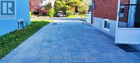 Toronto (Clanton Park) apartment for rent - A sidewalk in front of a brick building with a REALTOR sign.