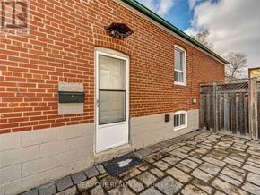 Toronto (Clanton Park) apartment for rent - A brick house with a white door and a small window above it.