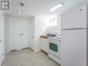 Toronto (Clanton Park) apartment for rent - A white kitchen with a fridge, oven and microwave.