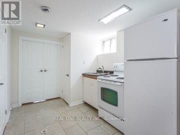Toronto (Clanton Park) apartment for rent - A white kitchen with a fridge, oven and microwave.