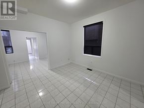 Toronto (Dovercourt-Wallace Emerson-Junction) apartment for rent - A white tiled room with a window and a door leading to another room.