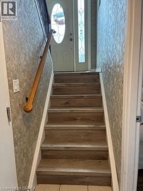 Paris apartment for rent - A staircase with a wooden handrail and tiled walls.
