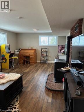 Paris apartment for rent - A living room with a black couch and a wooden floor.